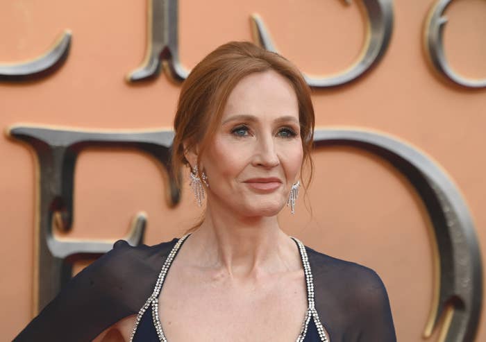 J.K. Rowling is dressed in elegant attire on a red carpet, wearing a dress with intricate beading and statement earrings