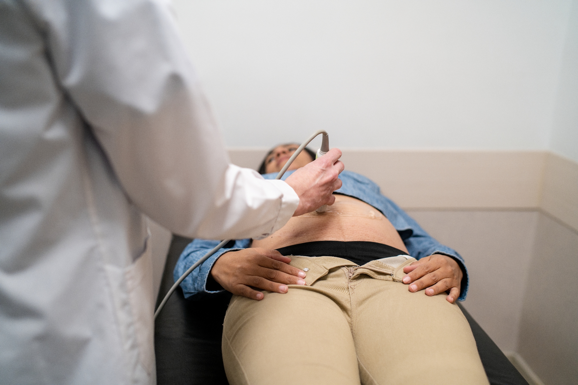 En person mottar en abdominal ultralyd fra en lege i medisinsk setting