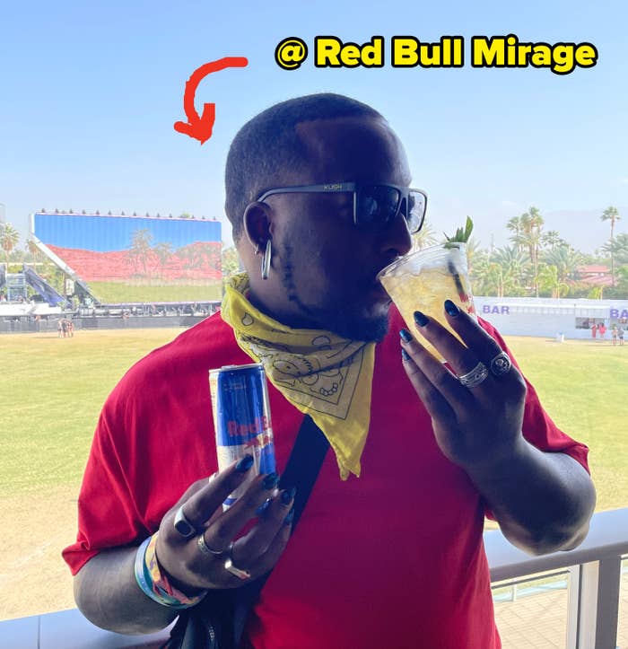Person at an outdoor event, holding a drink and a can, wearing sunglasses and a bandana