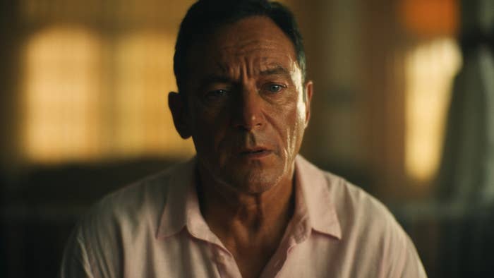 Person in a contemplative moment indoors, wearing a light shirt