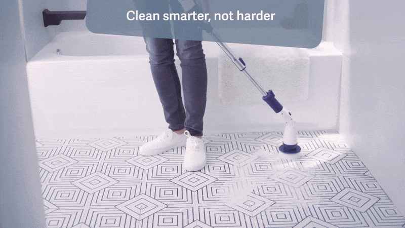 Person cleaning a tiled bath  level  with an electrical  scrubber. Text reads, 