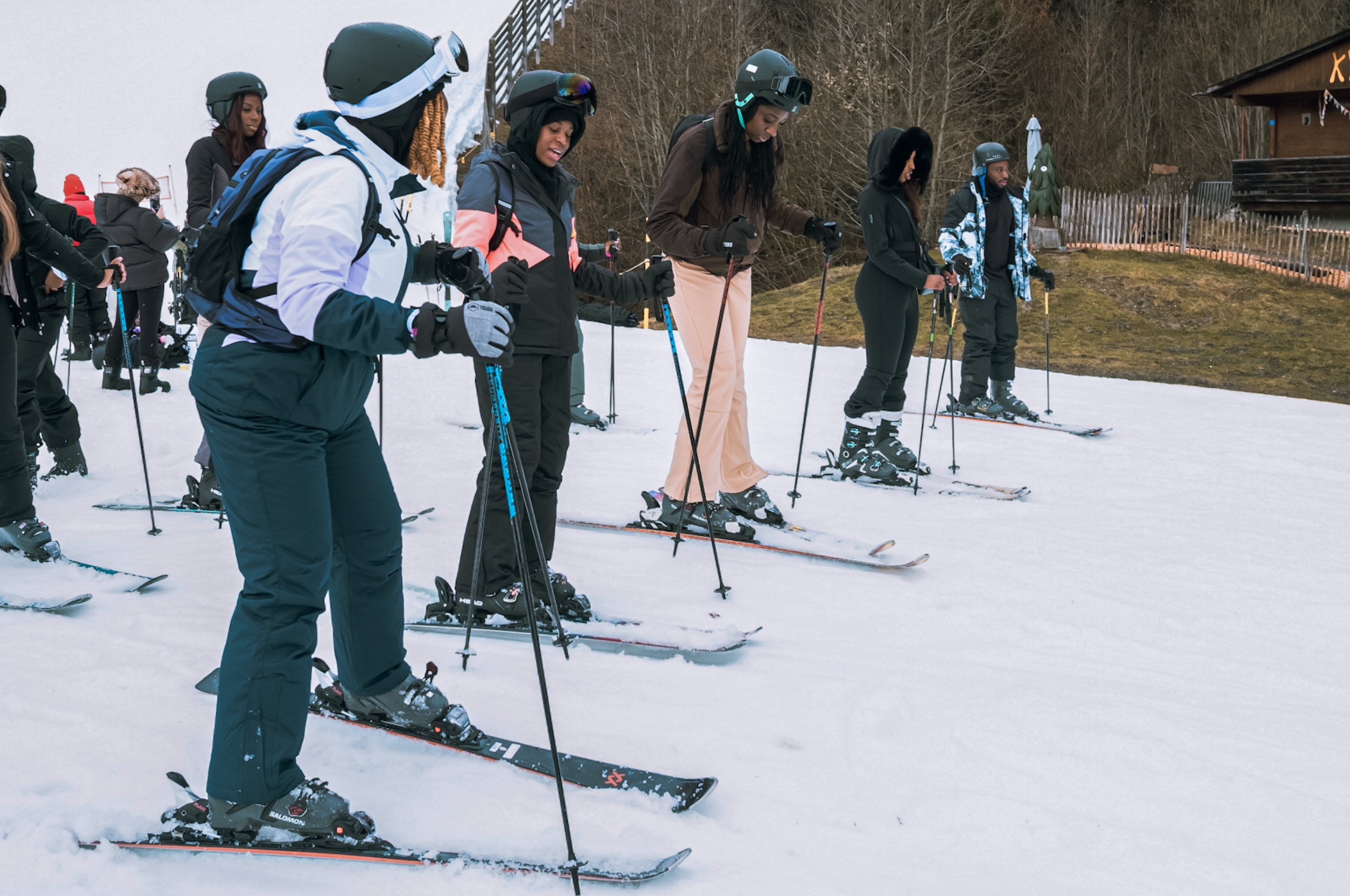 A group of people skiing on a gentle slope, wearing helmets and ski gear, seen enjoying the activity together
