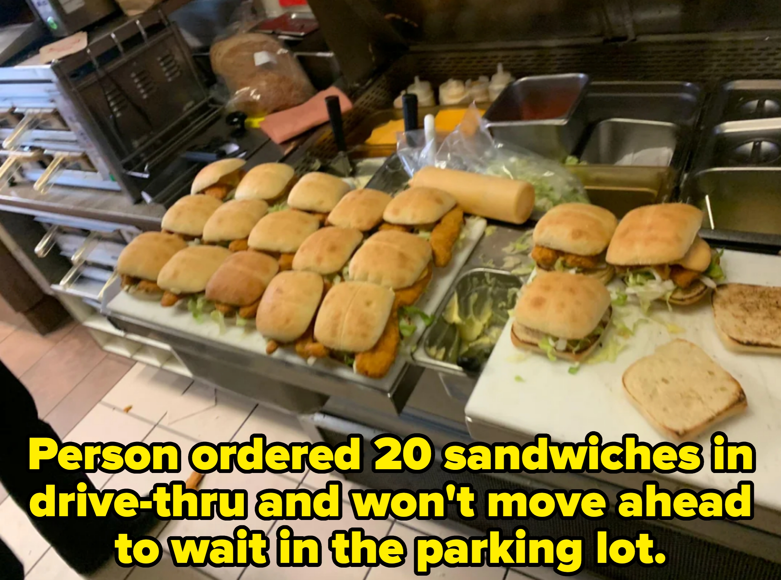 Multiple trays of prepared sandwiches with lettuce and meat in a kitchen setting. Caption: &quot;Person ordered 20 sandwiches in drive-thru and won&#x27;t move ahead to wait in the parking lot&quot;