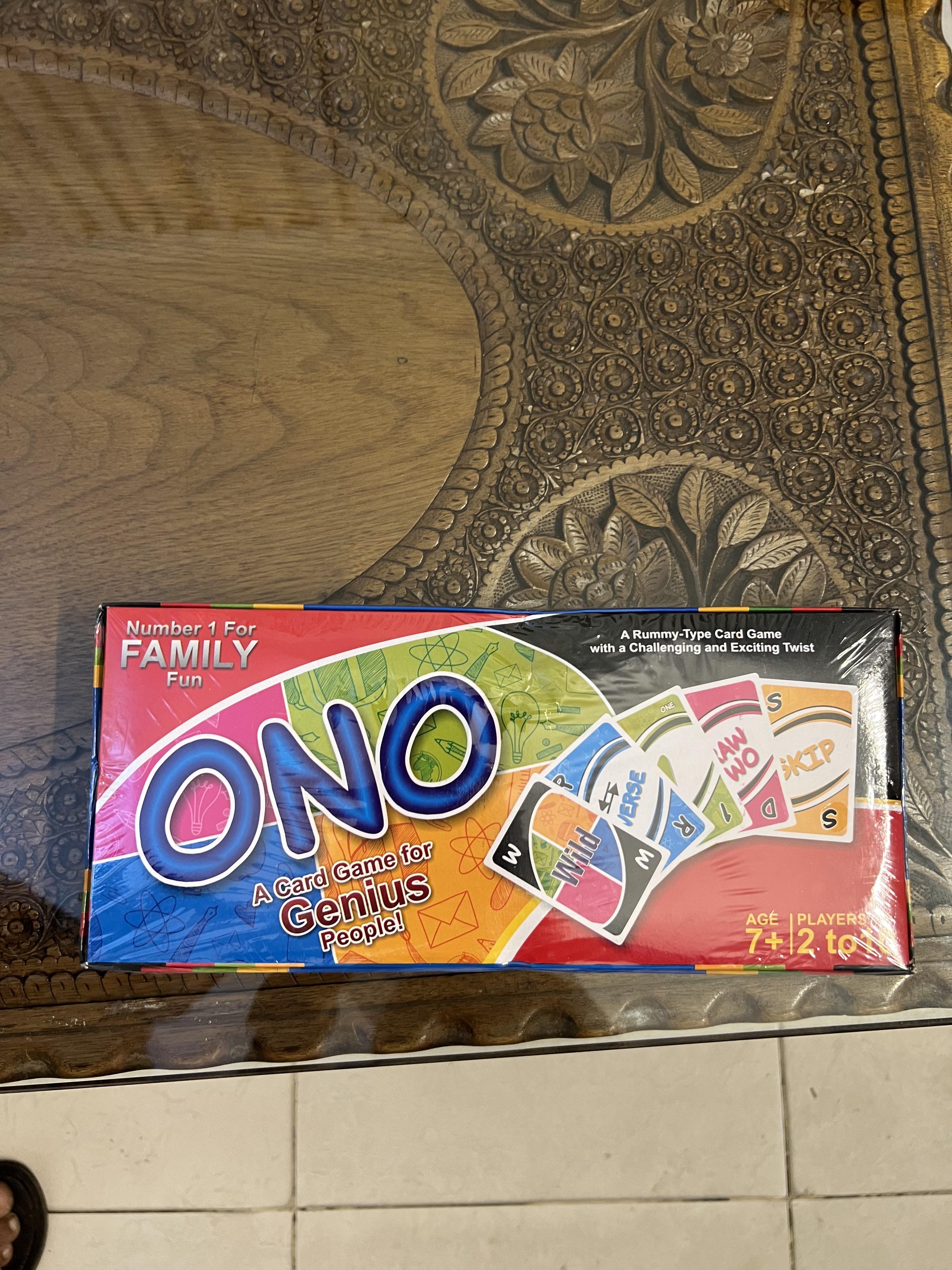 Box of "ONO," a family card game for ages 7 and up, featuring number and action cards on a wooden table