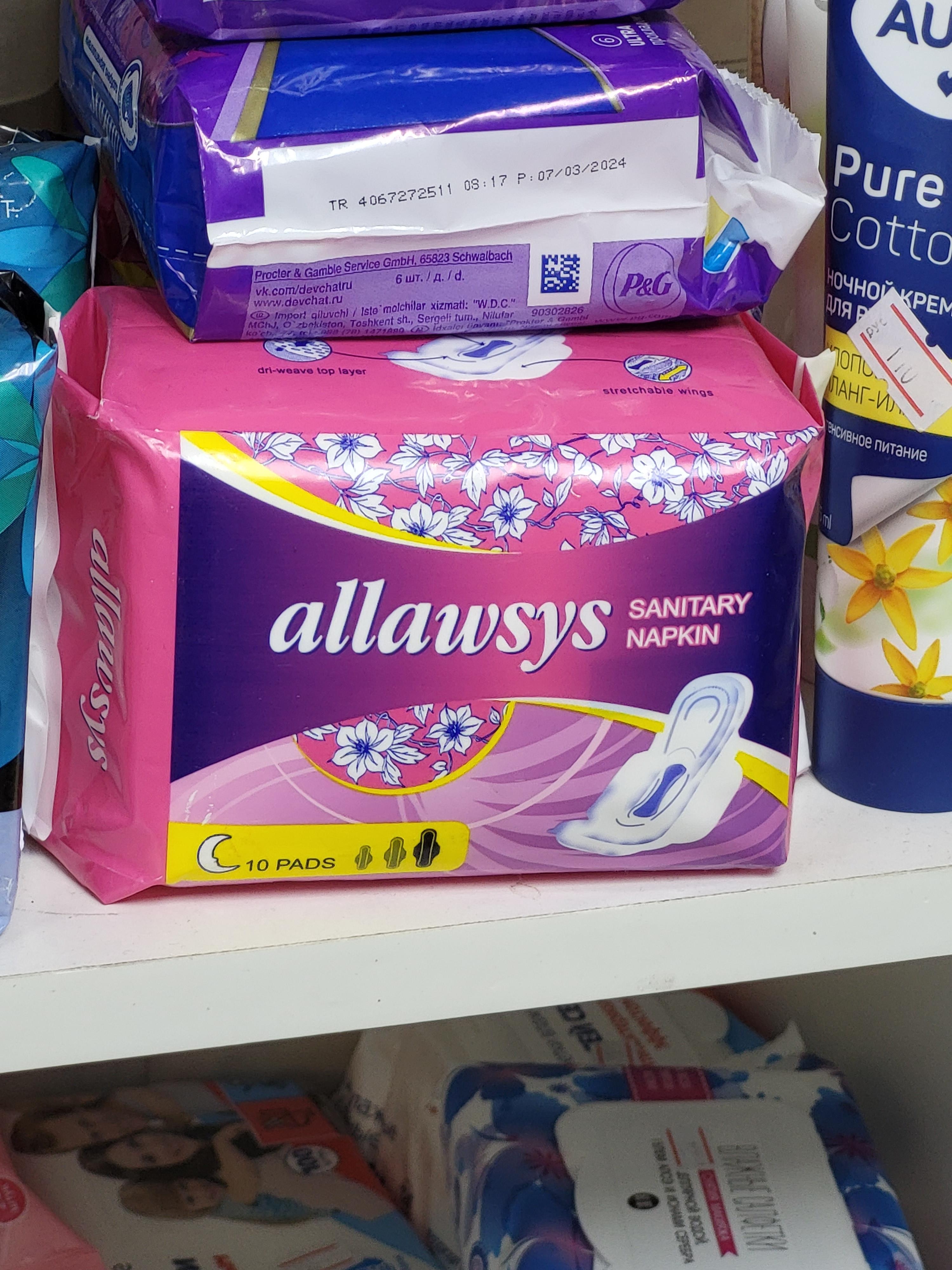 Package of Always sanitary napkins with floral design, on a store shelf among other hygiene products