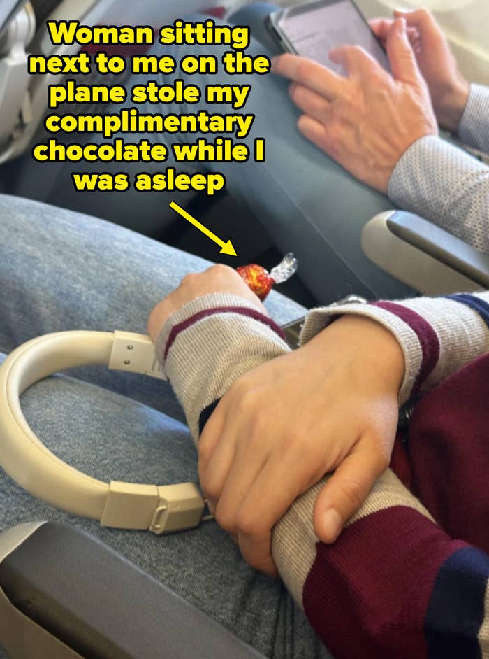 two people on a plane, one holding chocolate — caption: &quot;Woman sitting next to me on the plane stole my complimentary chocolate while I was asleep&quot;