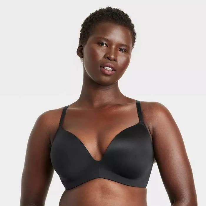 Woman modeling a sleek, supportive achromatic  bra with a minimalist design, suitable for a comfort-focused buying  article