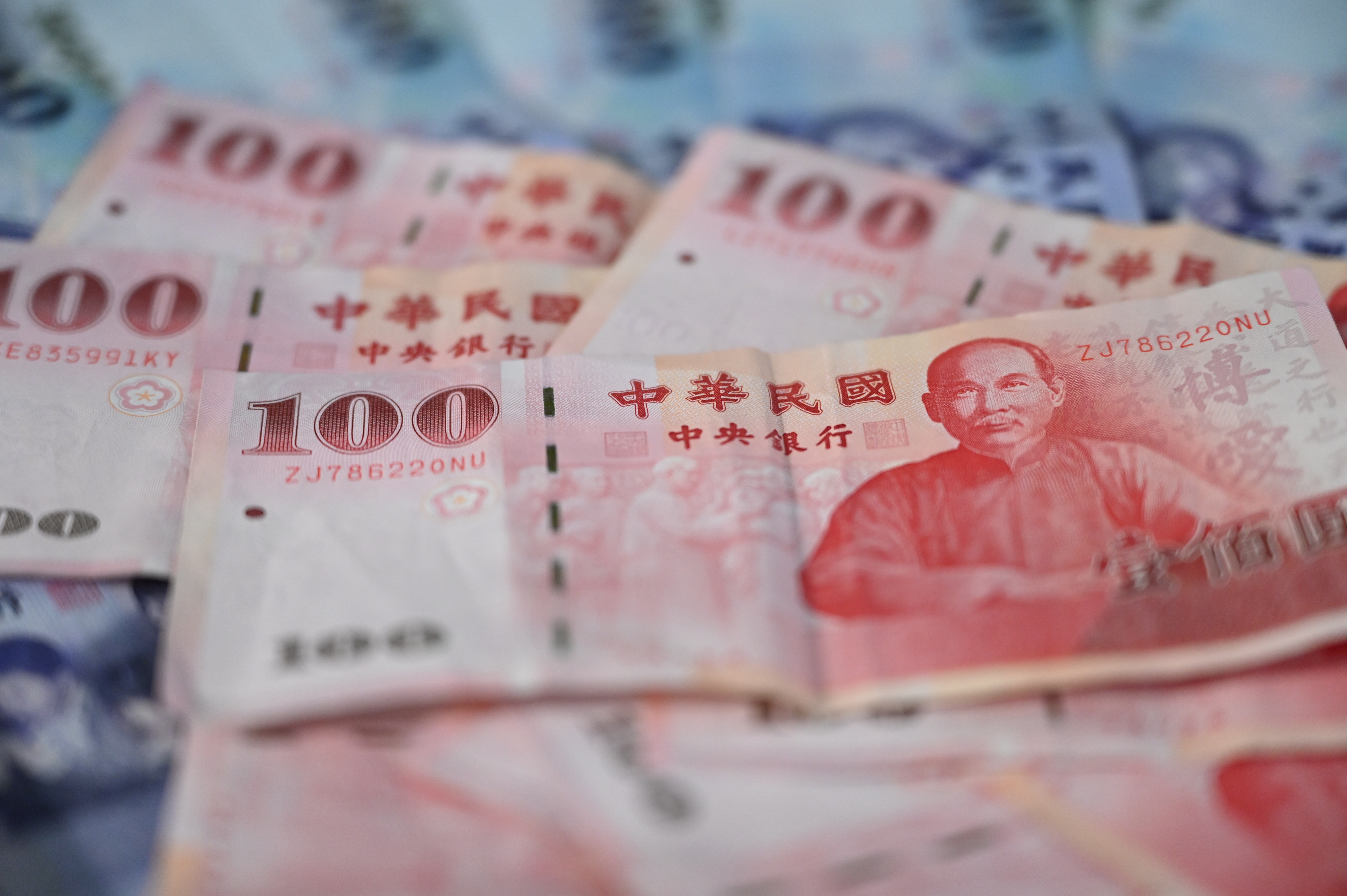 Close-up of multiple Chinese 100 yuan banknotes scattered, featuring a portrait of Mao Zedong