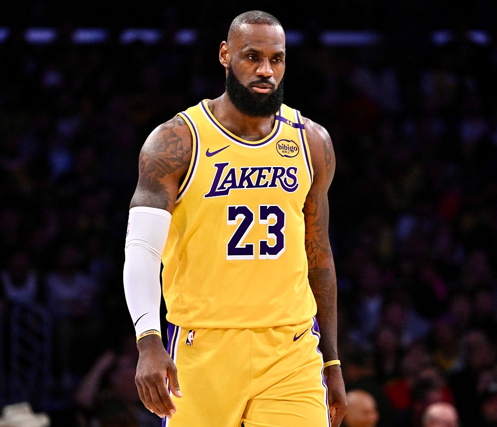 Basketball player in a Lakers jersey walking on a court during a game