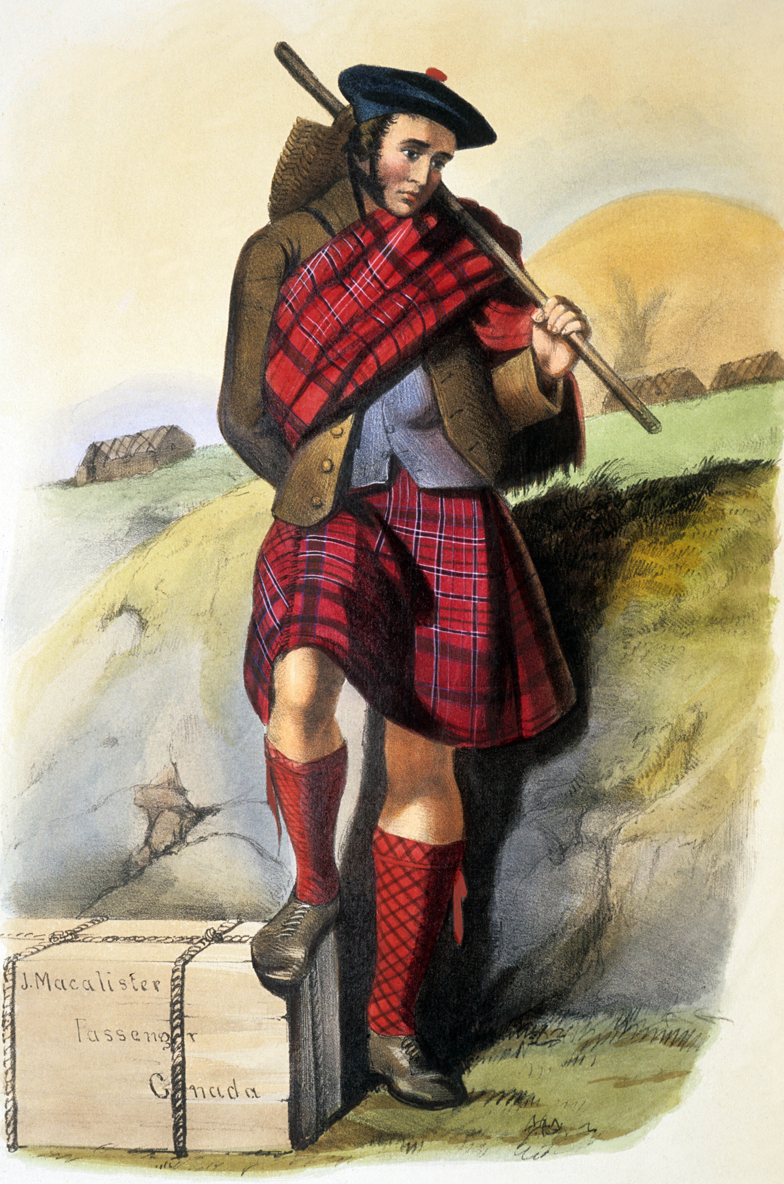A man in traditional Scottish attire, including a kilt and sash, poses outdoors with a stick and a wooden box marked &quot;J. Macalister Passenger Canada.&quot;