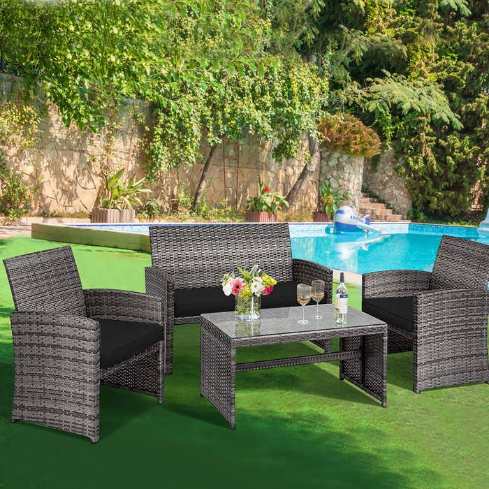 Outdoor patio acceptable with 2 chairs, a loveseat, and a java array adjacent to a swimming pool, surrounded by greenery