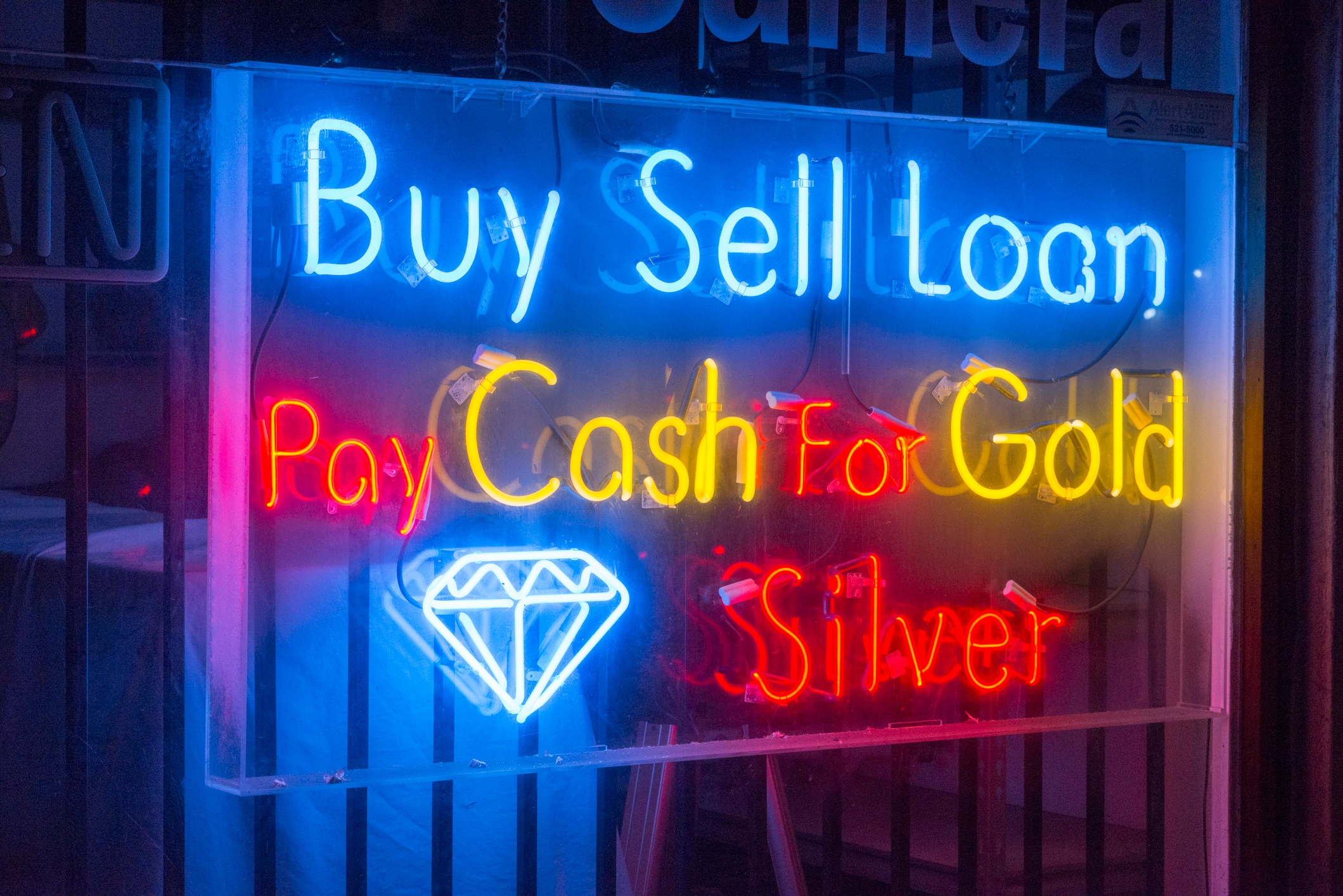 Neon sign reads: &quot;Buy Sell Loan. Pay Cash For Gold &amp;amp; Silver,&quot; with a diamond symbol