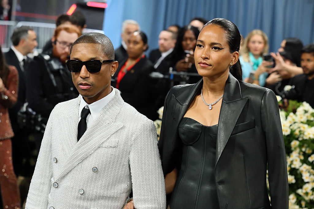 he wears sunglasses, and she has a silver necklace on a chunky chain