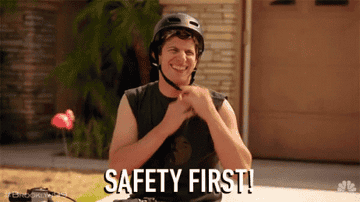 A person wearing a helmet smiles and gives a thumbs-up. The text "SAFETY FIRST" is displayed below