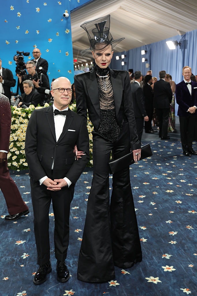 Richie in a classic tux and Jordan in wide-legged pants with a sparkly waistcoat and tulle top hat