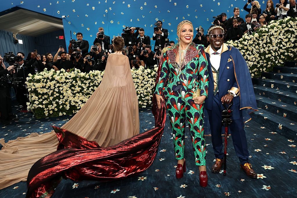 Laurie in a floral suit with a cape, and Bobby in a suit with a cape