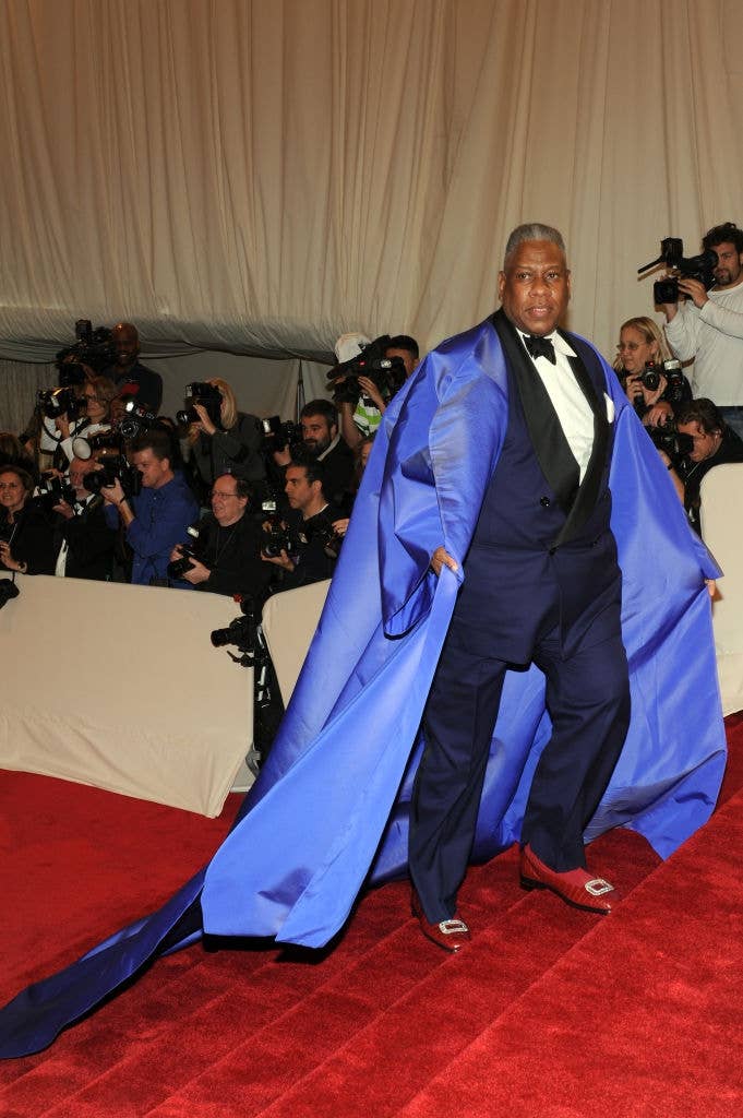 Andre in a tuxedo with a dramatic cape draped over his shoulders as he walked up the steps