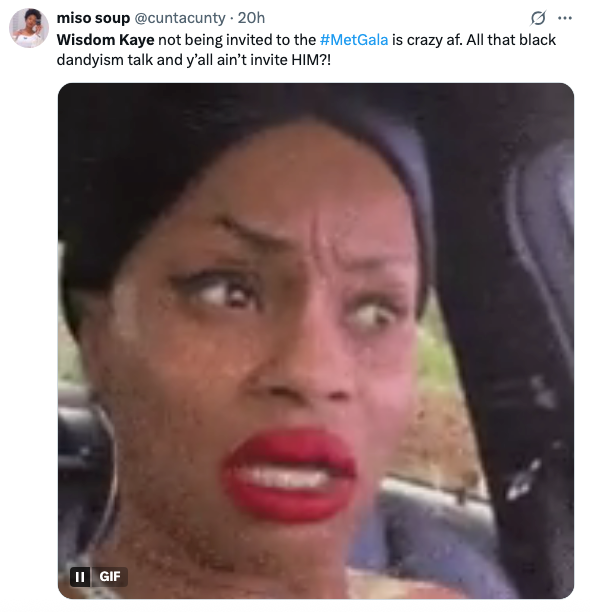 A concerned woman with a surprised expression is captured in a meme. The caption questions why Wisdom Kaye wasn't invited to the Met Gala