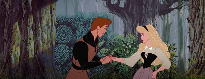 Prince Philip and Aurora holding hands in a wooded grove