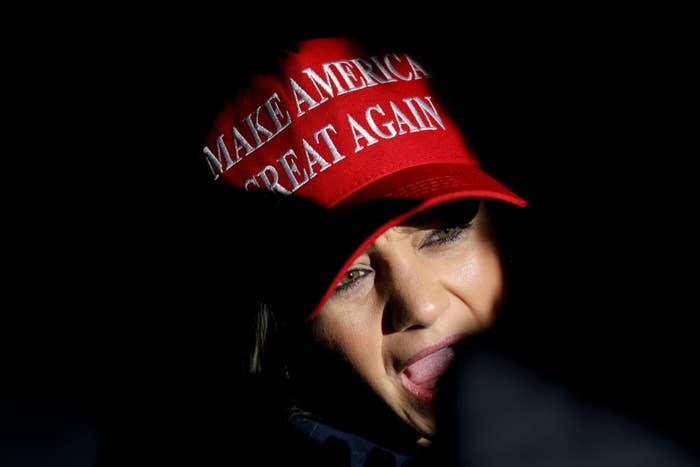Person partially obscured, wearing a red "Make America Great Again" cap, with a visible expression
