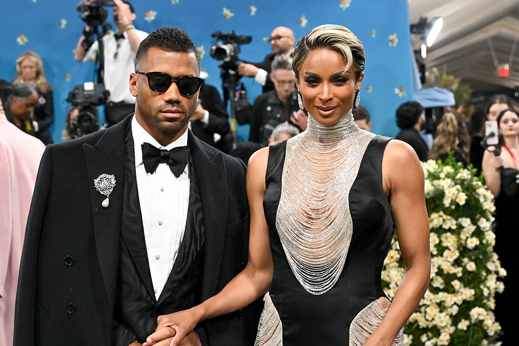 he has sunglasses and a silver brooch, and she has silver fringe on her neckline, chest, and sides