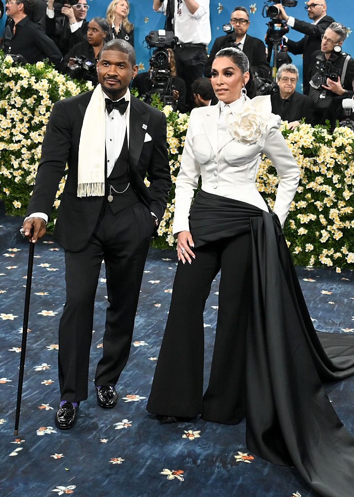 Usher in a tuxedo with a fringed scarf and cane, Jennifer in a blazer with a floral accent