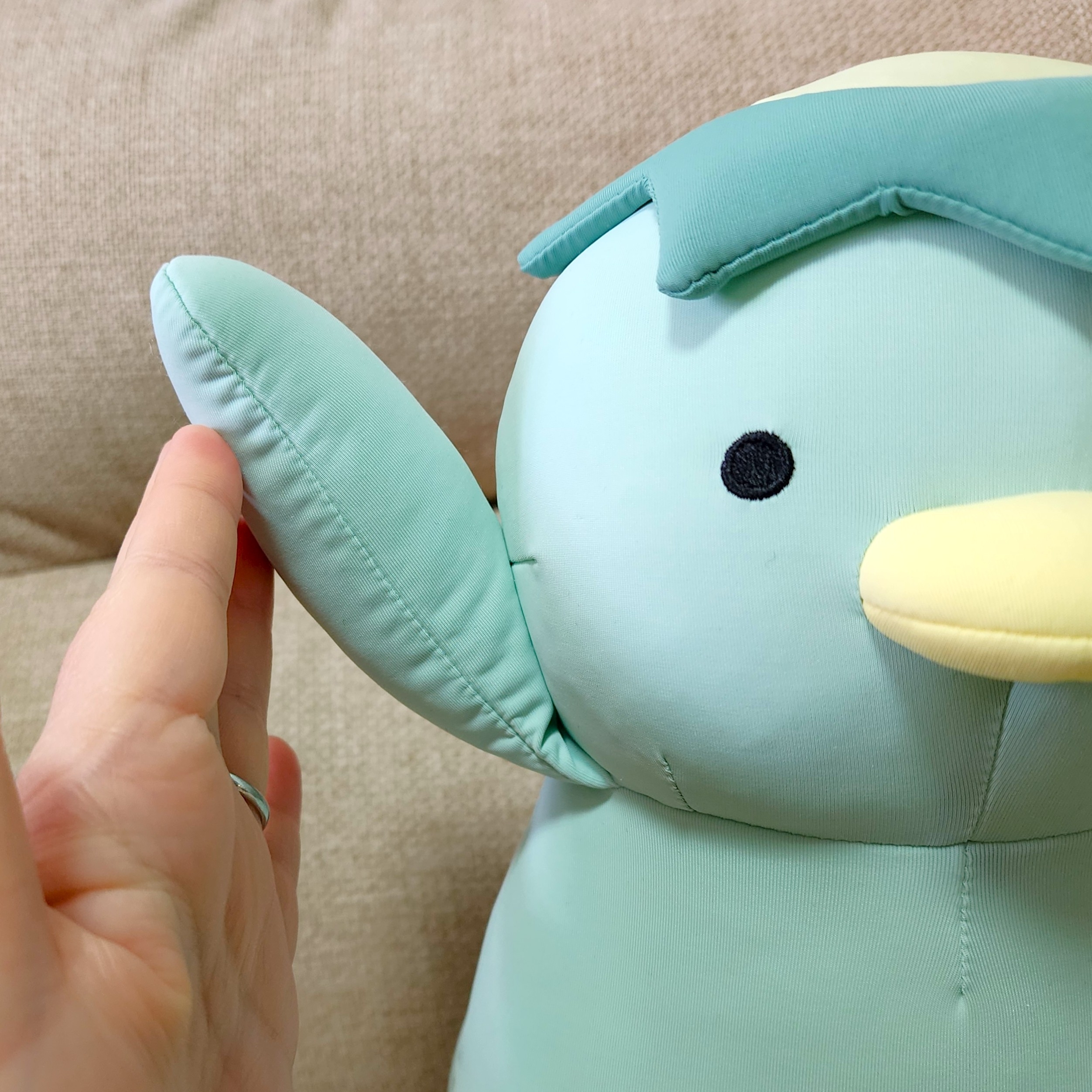 ぬいぐるみの手を、人が優しく持っている様子。