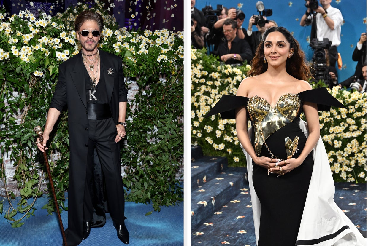 Two individuals on a blue carpet. Left: person in a long coat with cane. Right: person in a fitted dress with metallic bodice