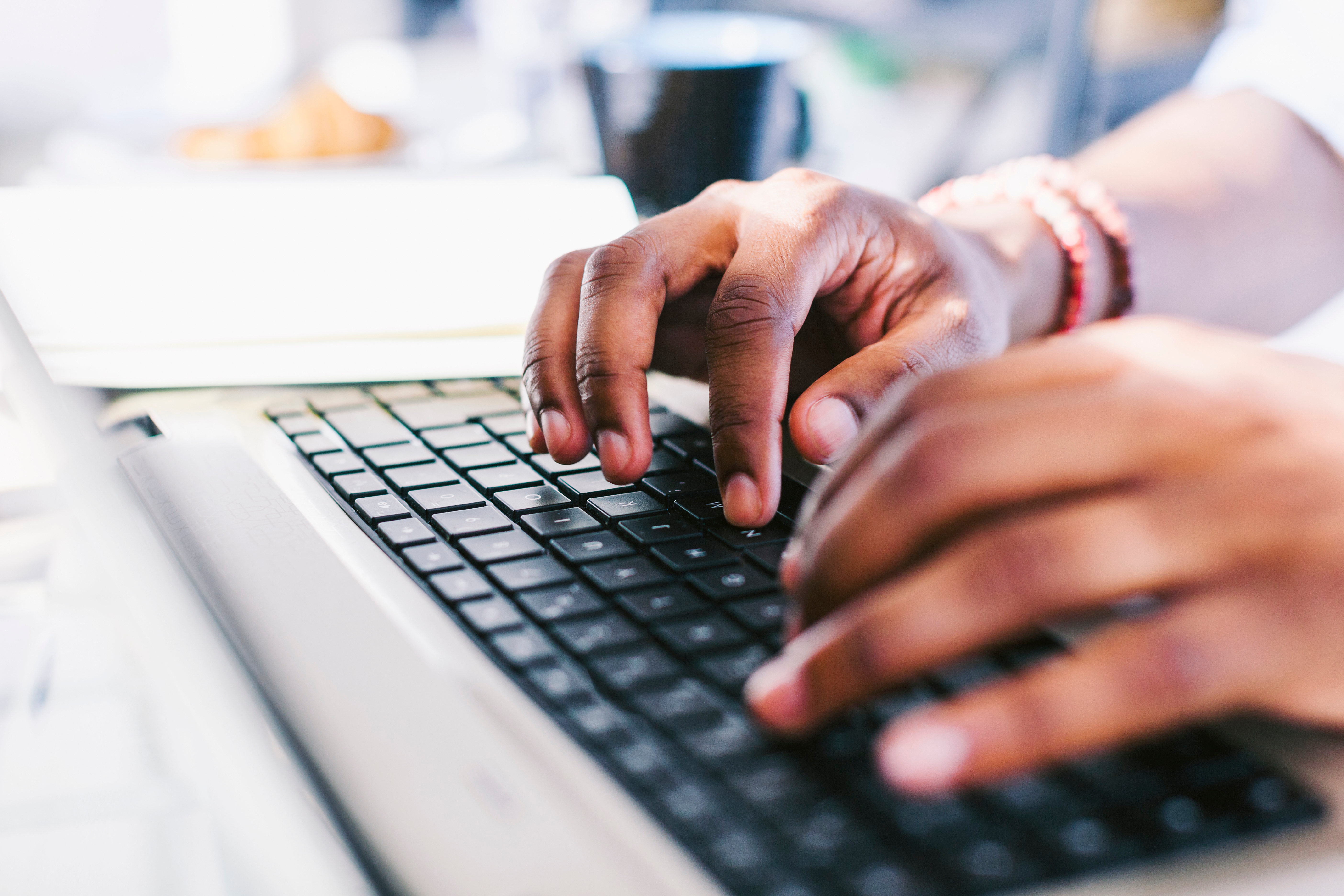 Hands typing on a laptop keyboard.