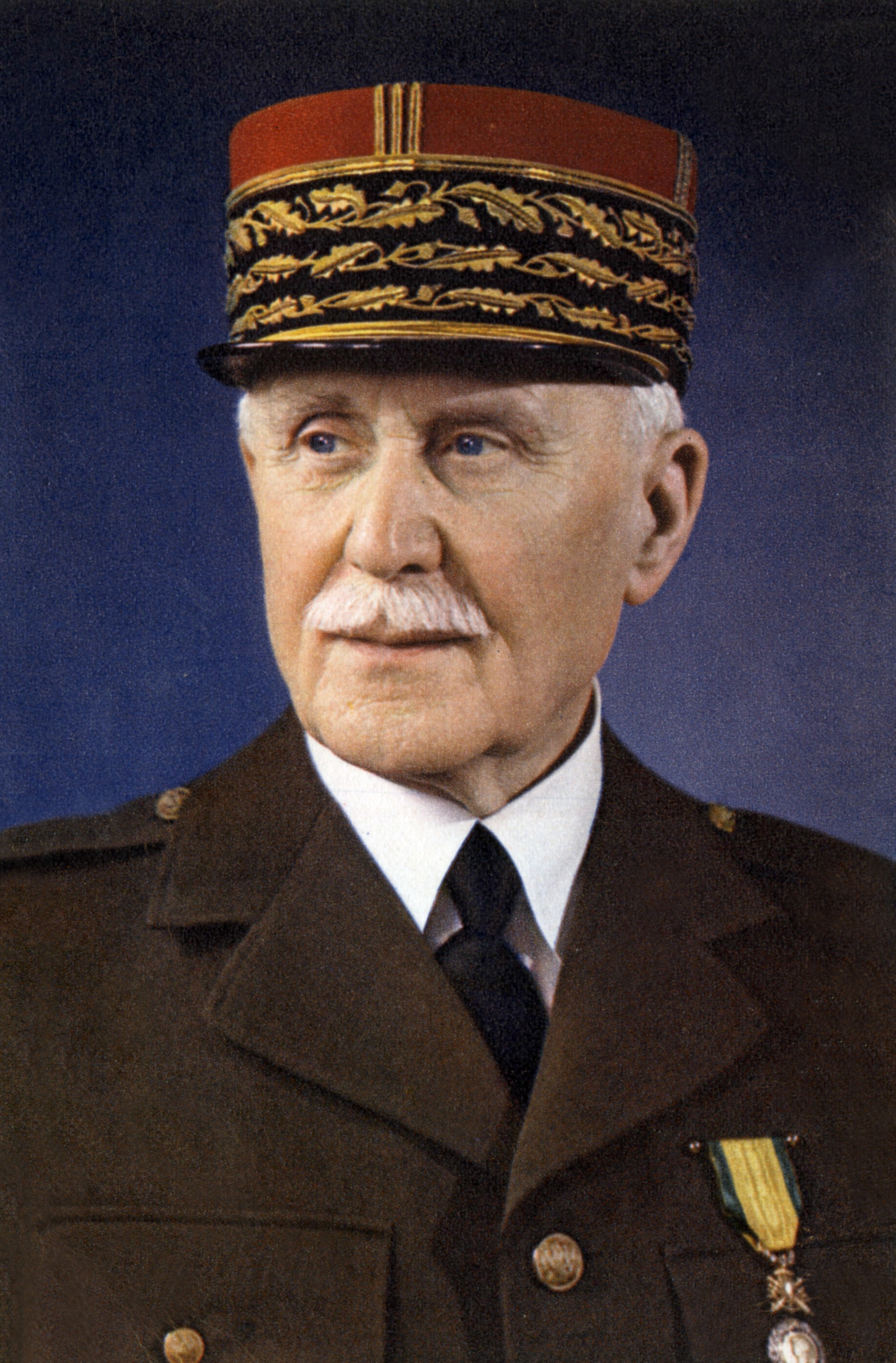 Older man in a military uniform with decorative hat and medals, looking to the side