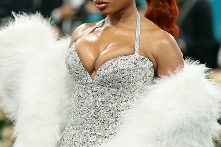 Megan Thee Stallion in a shimmering gown with faux fur wrap on the Met Gala red carpet