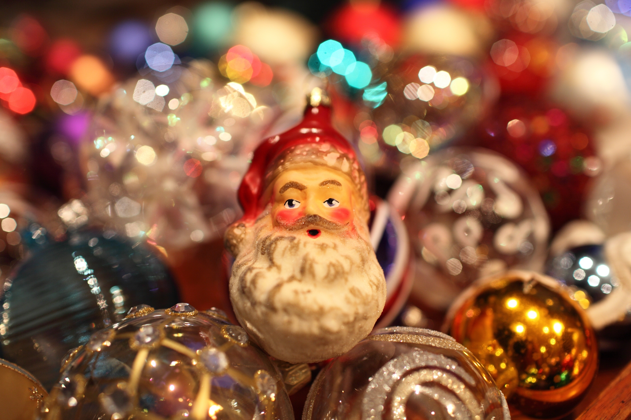 Santa ornament among various decorative baubles and shiny ornaments