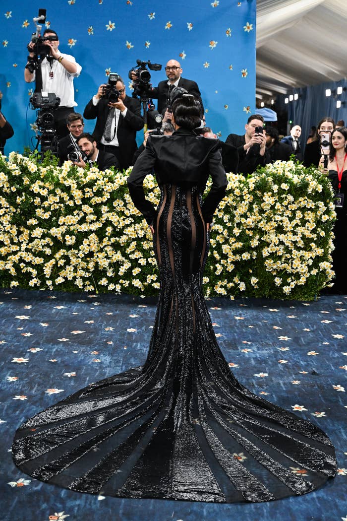 Halle Berry from the back in an elegant, form-fitting black gown with beaded train