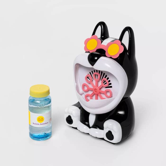 Toy bubble instrumentality shaped similar a canine with angiosperm sunglasses, adjacent to a vessel of bubble solution