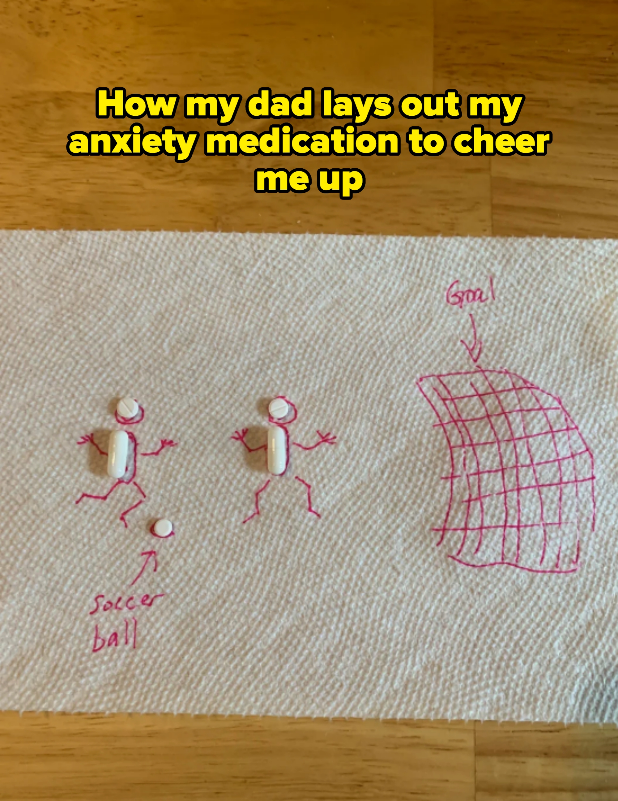 Pills are placed on two drawn stick figures who are depicted with a goalpost and a soccer ball. Caption: "How my dad lays out my anxiety medication to cheer me up"