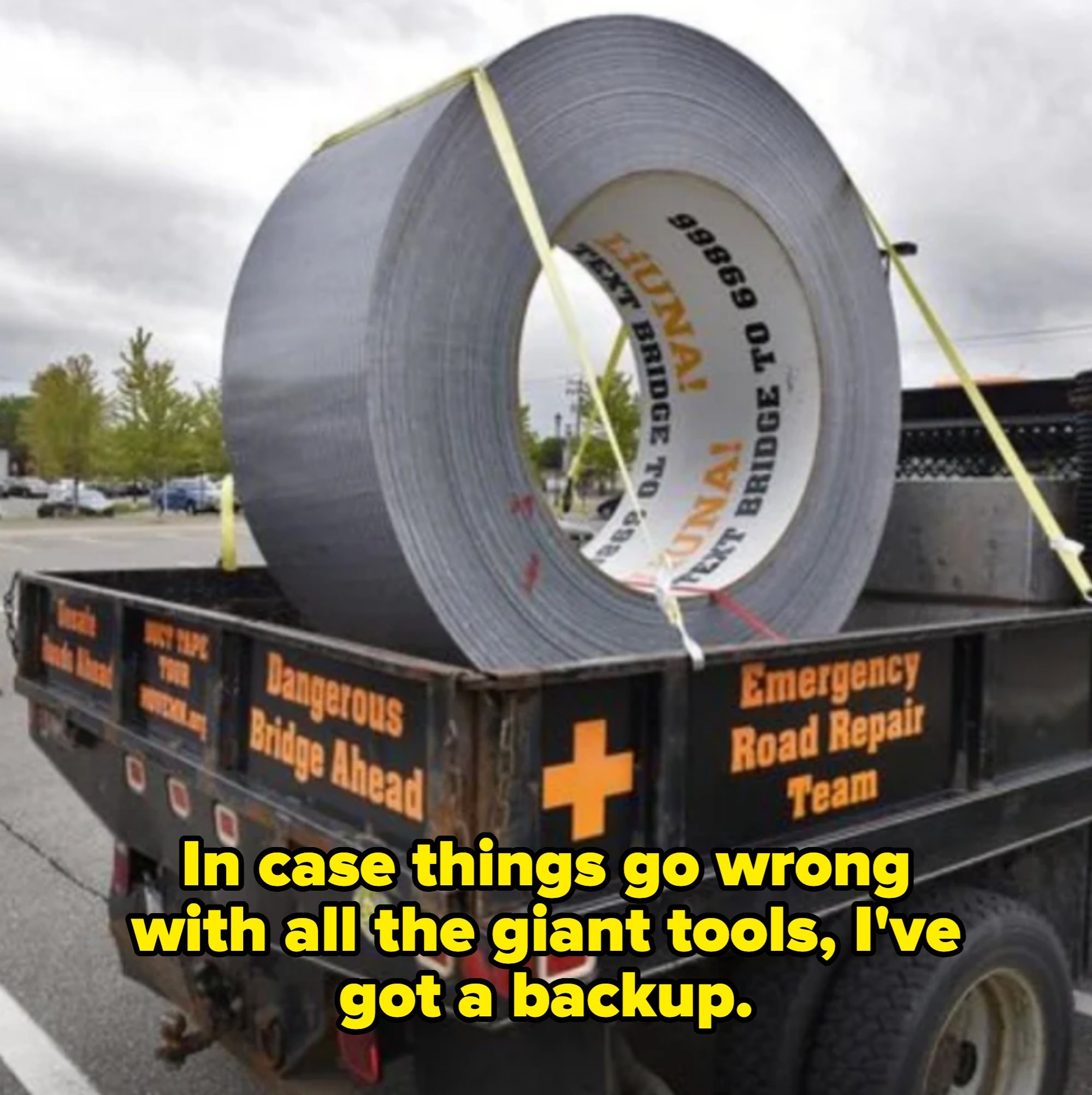 Giant roll of duct tape in bed of truck labeled "Emergency Road Repair Team." Caption: "In case things go wrong with all the giant tools, I've got a backup"
