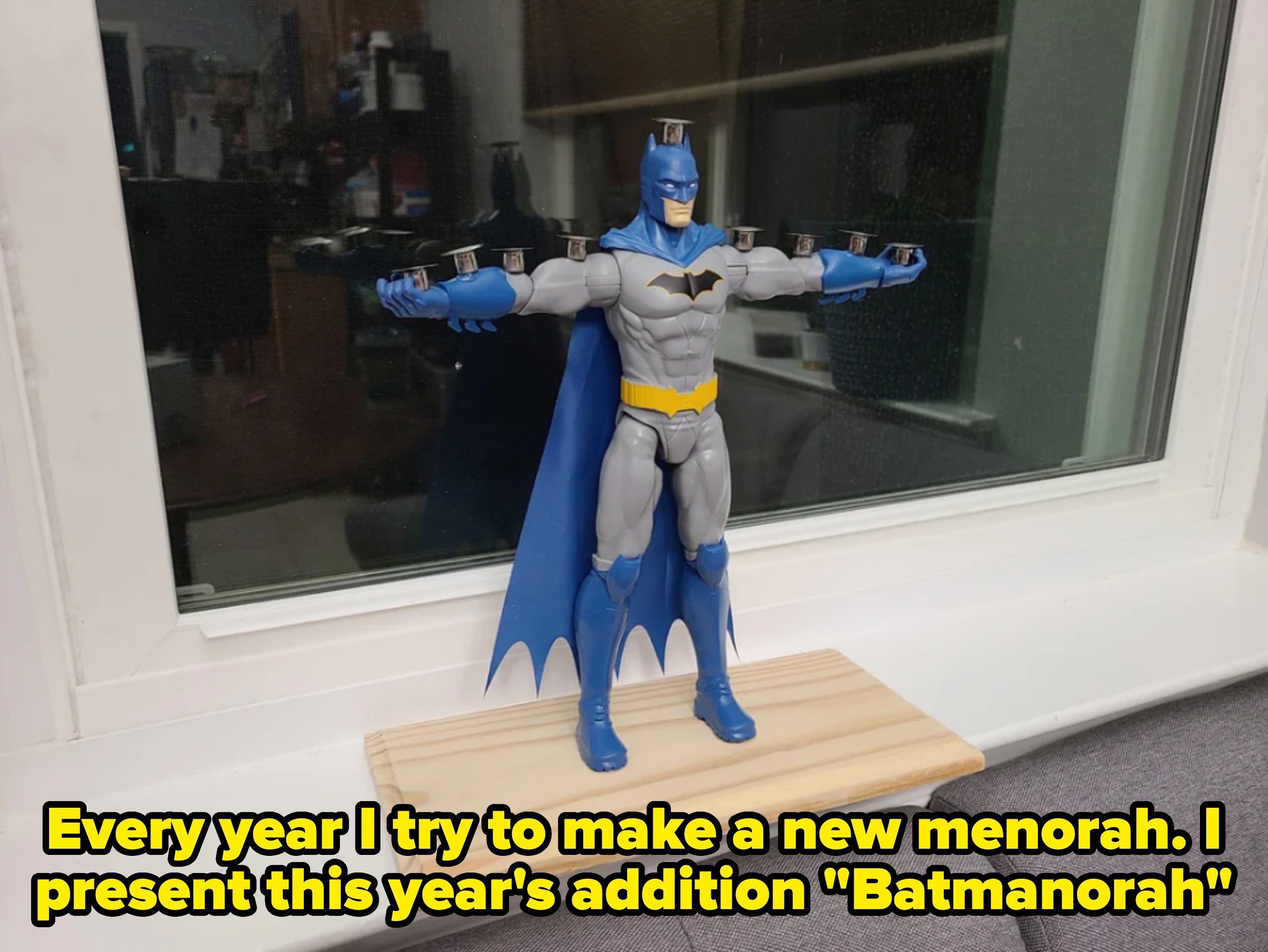 Batman action figure made into a menorah. Caption: "Every year I try to make a new menorah. I present this year's addition 'Batmanorah'"