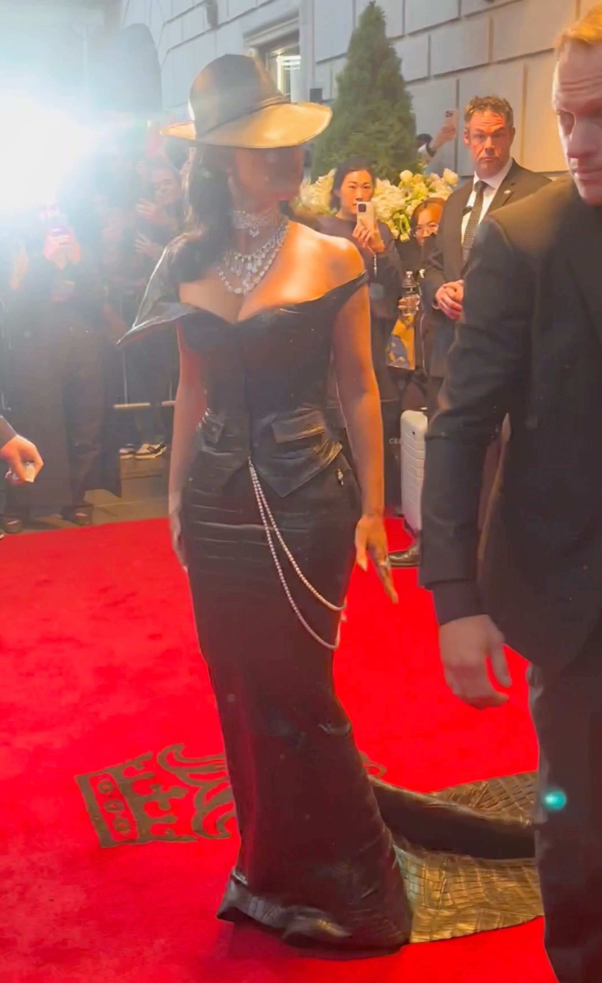 Kim Kardashian seemingly unhappy as a security guard steps on her dress