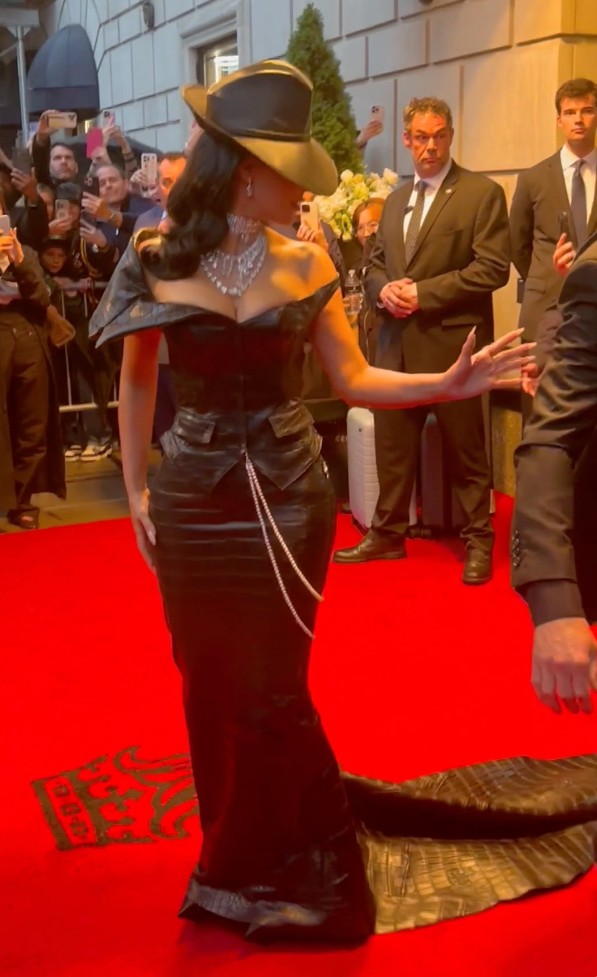 Kim Kardashian on a red carpet, speaking to someone off-camera