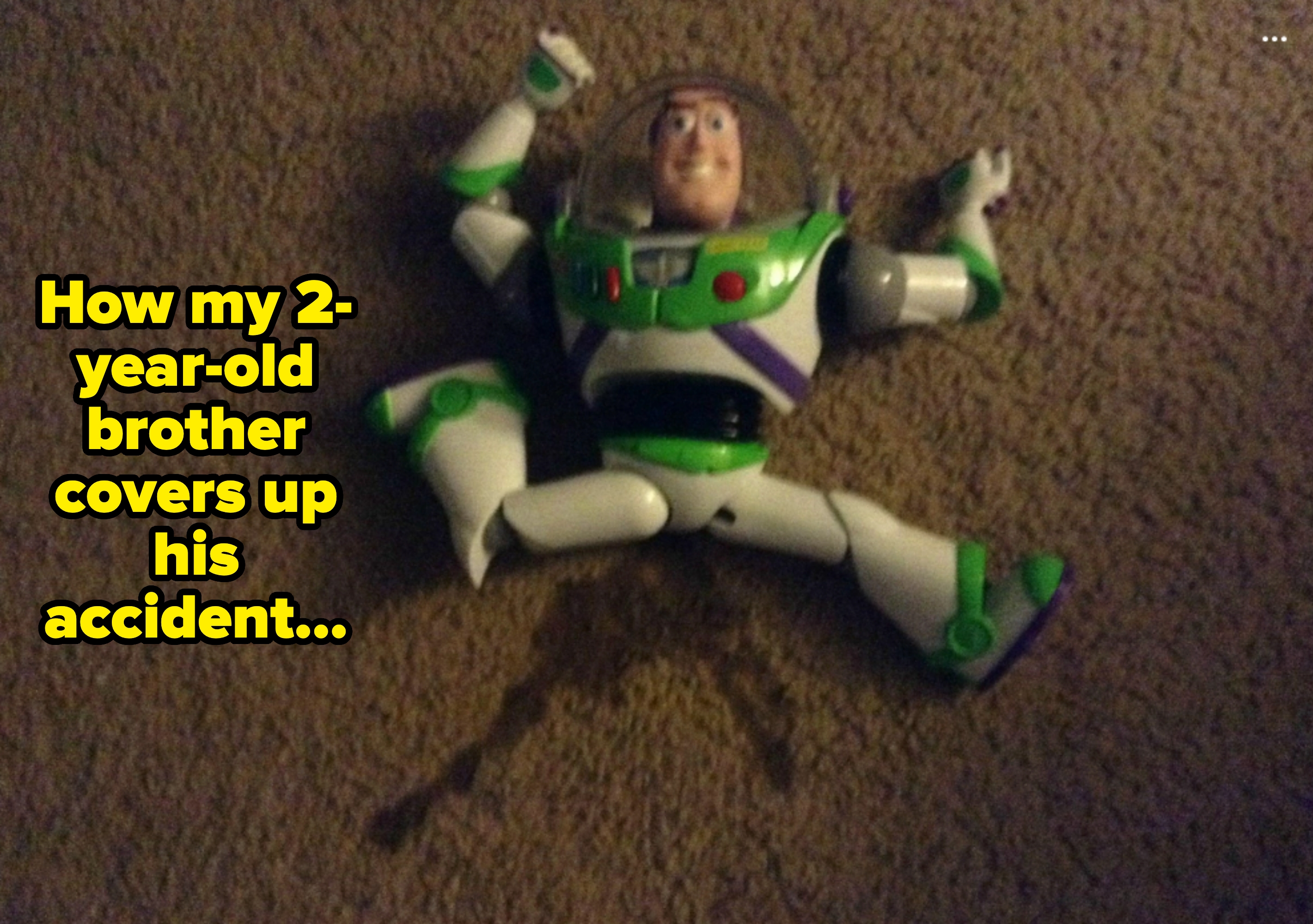 Buzz Lightyear action figure positioned over wet carpet stain. Caption: "How my 2-year-old brother covers up his accident"
