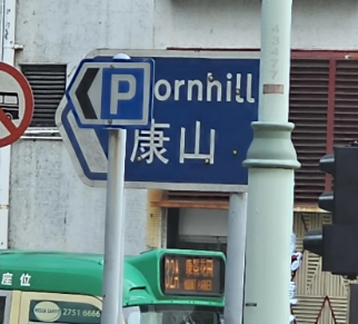 Parking sign partially covering another sign so it appears to read "Pornhill"