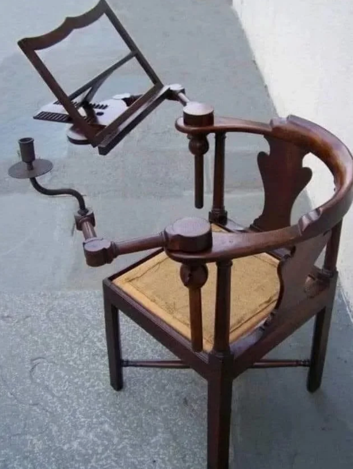 Antique wooden chair with a built-in music stand and candleholder, designed for musicians to read sheet music while seated