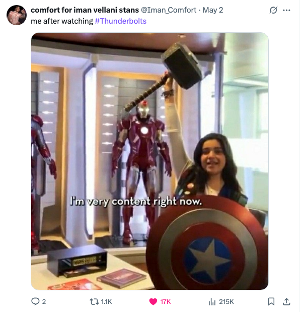 Person smiling, holding Thor's hammer and Captain America's shield, with Iron Man suits displayed behind. Social media post caption: "me after watching #Thunderbolts"