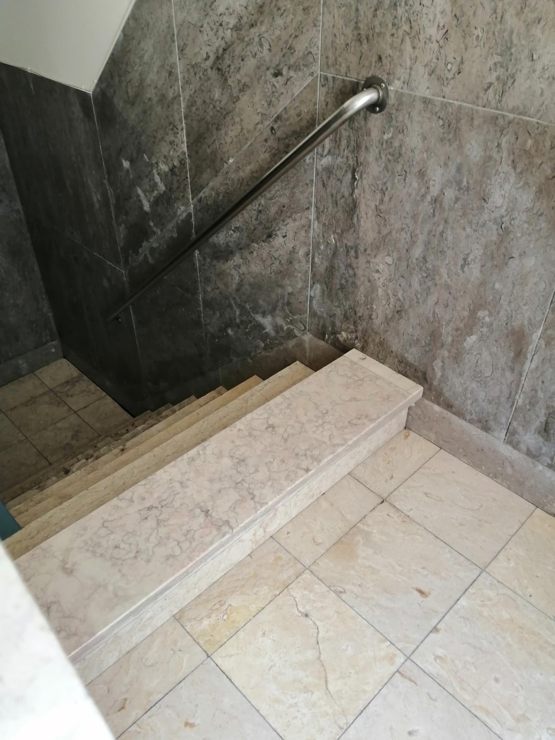 A staircase with a high step blocking access, creating an accessibility barrier