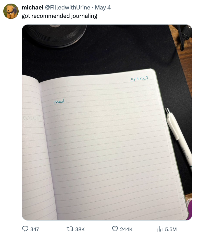 Open journal with date 5/4/23 on the right page and one word, "Wow." Pen and phone visible nearby