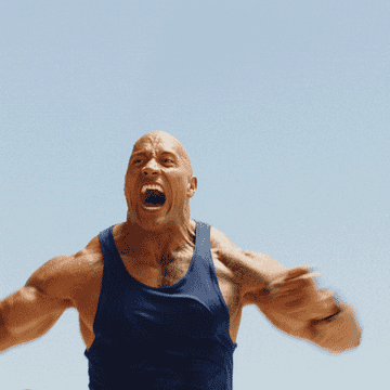A muscular man in a tank top is energetically running on a beach, shouting with excitement