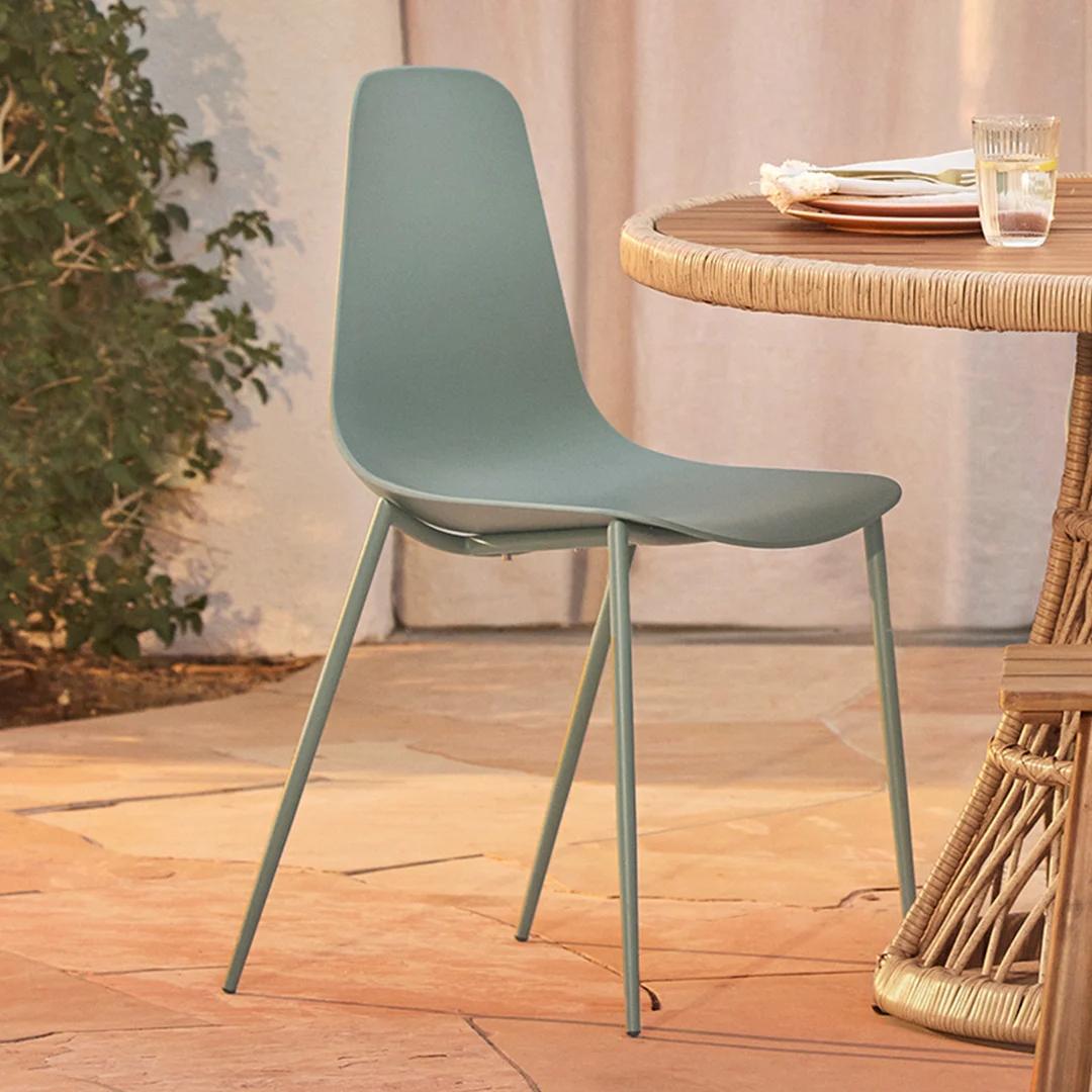 Modern minimalist chair next to a table set for dining outdoors