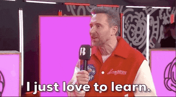 Man enthusiastically speaking into a microphone, wearing a red and white jacket. Text overlay: "I just love to learn."