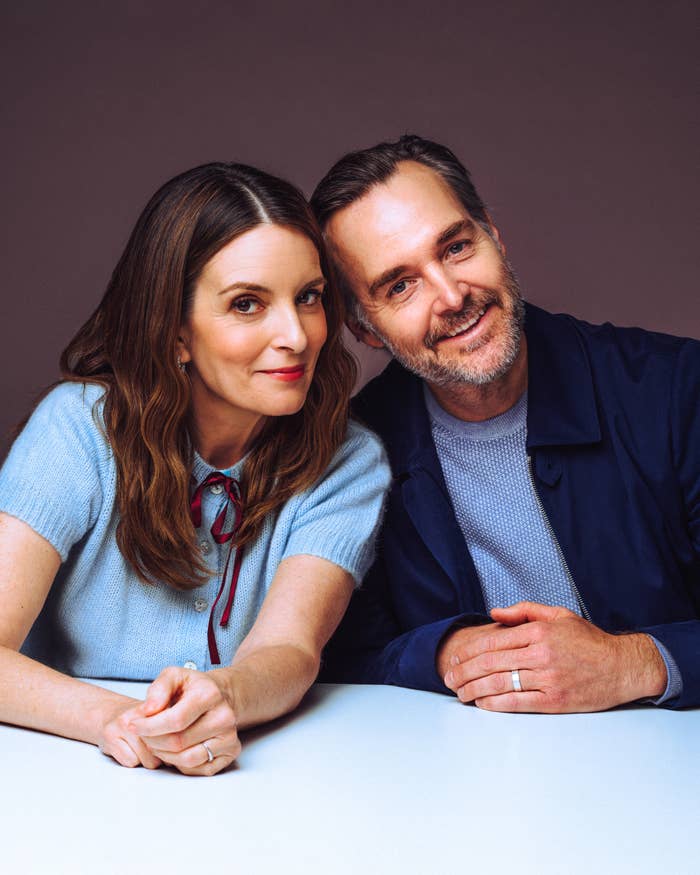 Two radical sitting together, smiling warmly astatine the camera, hands clasped connected the table. One wears a airy sweater with a ribbon, the different a jacket