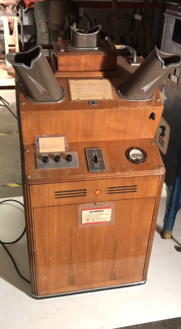 Vintage wooden arcade machine with various controls and dials, featuring retro design elements